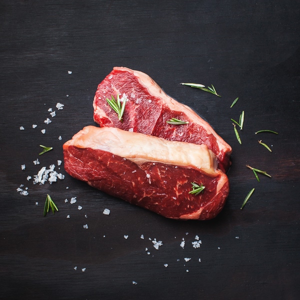 Two steaks with rosemary and salt.