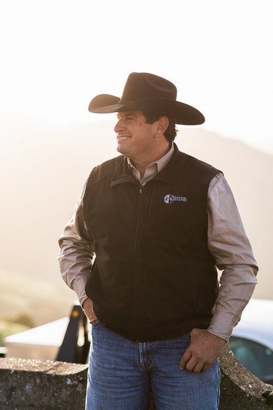 A Hearst Ranch team member wearing a black cowboy hat and vest.