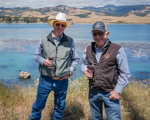 Steve Hearst, left, and Jim Saunders, right, co-owners and founders of Hearst Ranch Winery at San Simeon Pint with Hearst Castle in the background.