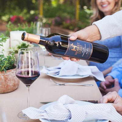 A bottle of 2016 Cabernet Franc from Hearst Ranch Winery being poured into a wine glass.