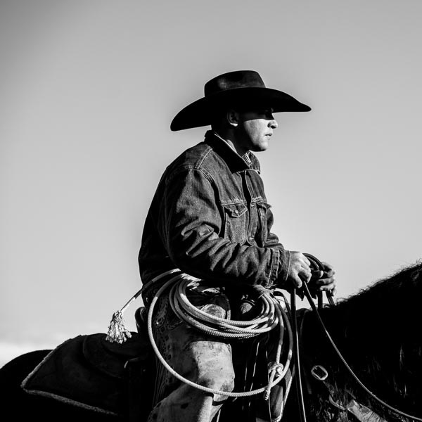 A cowboy rides horseback.