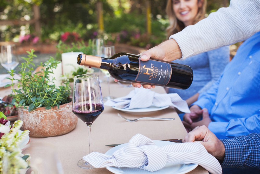 A bottle of 2016 Cabernet Franc from Hearst Ranch Winery being poured into a wine glass.