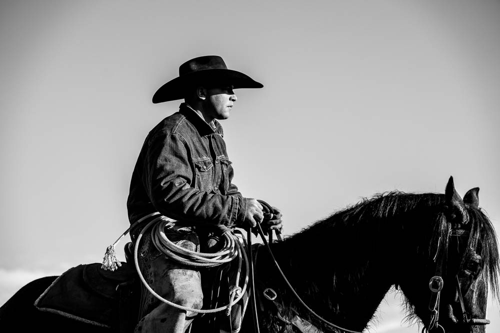 A cowboy rides horseback.