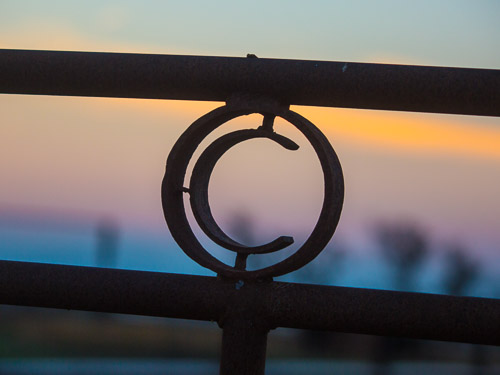 The Cholame C logo on an iron fence.