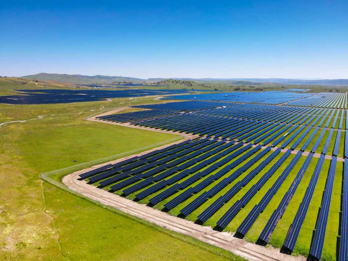 An aerial shot of the 280-megawatt California Flats solar project. The hills and land is covered in green grass.